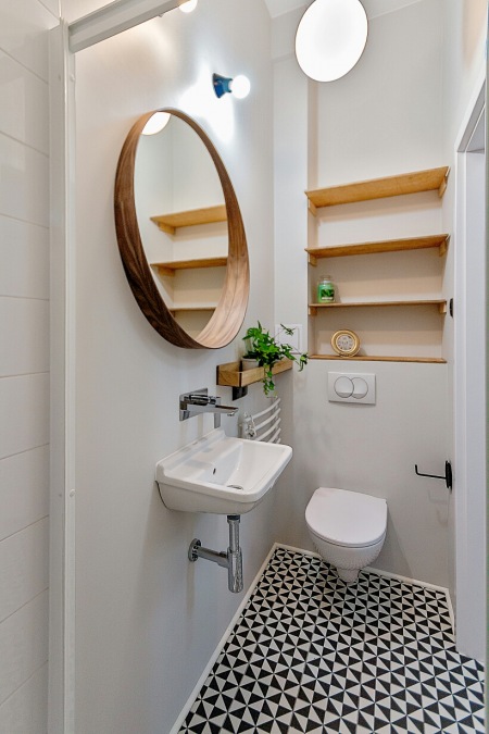 Drewniane lustro i półki w białej łazience