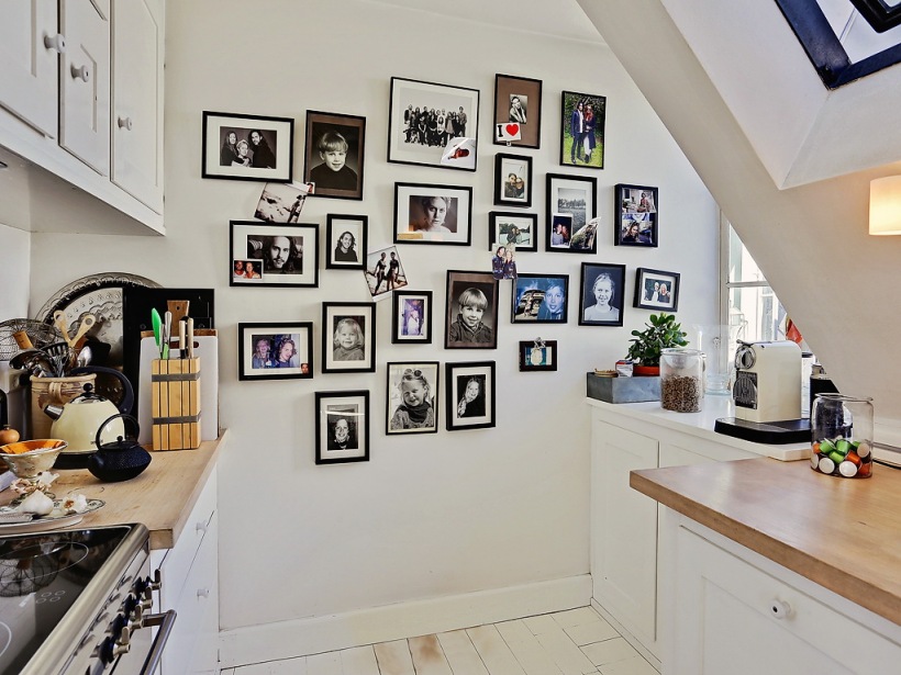 Jasna kuchnia pod skosami z galerią zdjęć na ścianie