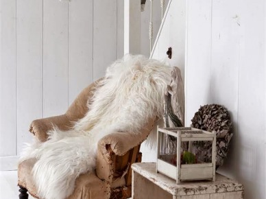 Beżowy fotel vintage,patynowany drewniany stołek,biały futrzak przy drewnianych malowanych na biało schodach (27109)