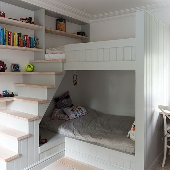 Piętrowe białe łóżka z drewnianymi półkami i schodkami