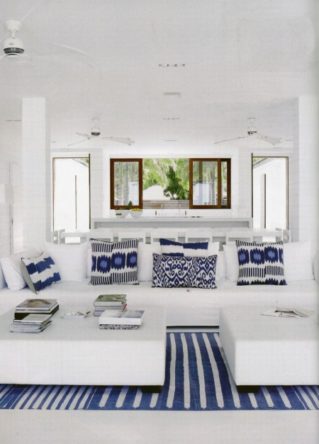 Biały salon z kobaltowymi poduszkami w nadmorskim domu przy plaży