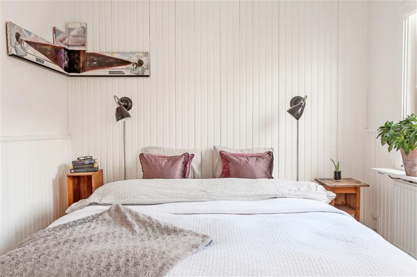 Biała sypialnia skandynawska z drewnianą ścianą z białych desek
