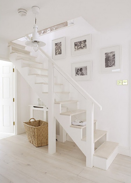 Aranżacja z białymi schodami w przedpokoju  letniego domu z drewna