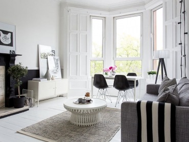 jedno z najpiękniejszych mieszkań w stylu skandynawskim ! wow ! białe wnętrze doskonale połączone z czarnymi meblami, czarnymi ścianami i biało-czarnymi dekoracjami. Elegancki kominek w marmurze skomponowany ze skandynawskimi meblami i w nowoczesnym stylu. Stare połączone z nowym, czarne z białym w bardzo subtelny sposób - to mieszkanie z klasą, gdzie białe, proste meble są subtelnie wkomponowane we wnętrze z białą podłogą z desek ozdobionymi pasiastymi, skandynawskimi dywanami. Pojawiają się nowoczesne, desingerskie stoliki, krzesła na płozach i oświetlenie z żarówek na kablach. Lekko mieszany styl nowoczesny w pięknym pomieszczeniu w stylowych murach kamienicy z wykuszem. Ściany udekorowane są subtelnymi , czarno-białymi fotografiami i grafikami. PIĘKNE...
