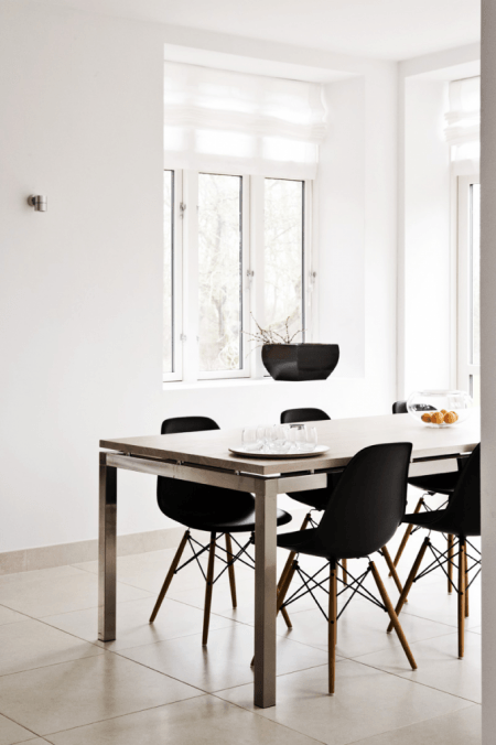 Stół z drewna w naturalnym kolorze i czarne krzesła w jadalni