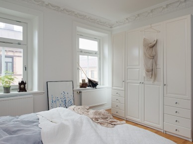 Białe szafy z szufladami w aranżacji skandynawskiej sypialni (22839)