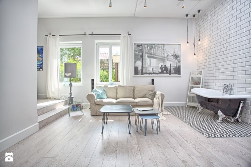 Jasny salon w stylu skandynawskim w zaskakującym połączeniu z aneksem kąpielowym