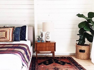 W aranżacji dużej sypialni główną rolę odgrywają naturalne materiały, czyli drewno i wiklina. Białe deski na ścianie...