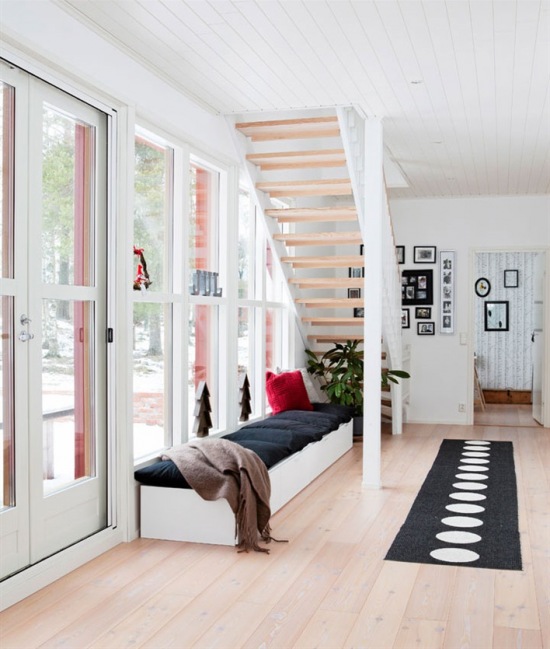 Drewniane ażurowe schody w przeszklonej, otwartej przestrzeni domu