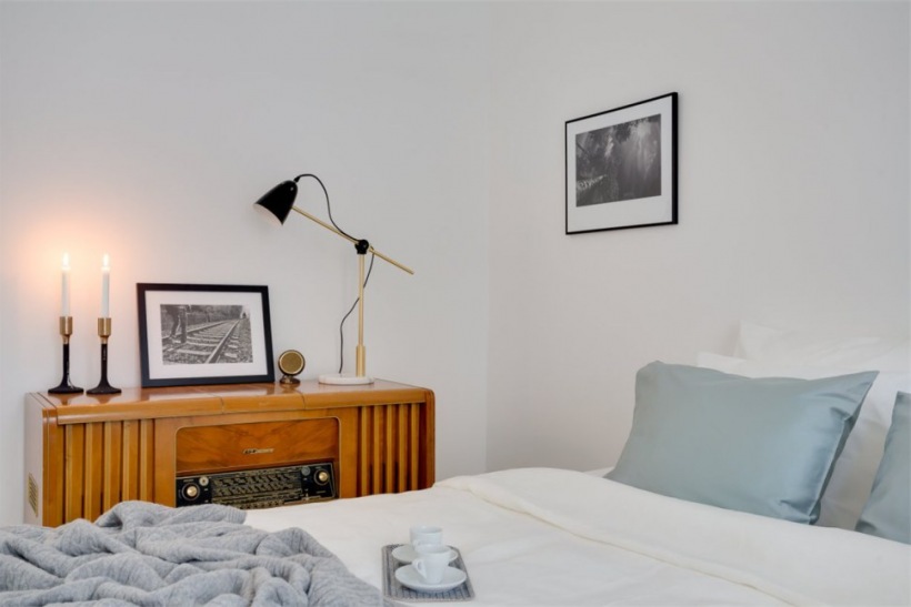 Komoda z lat 60-tych w białej sypialni skandynawskiej