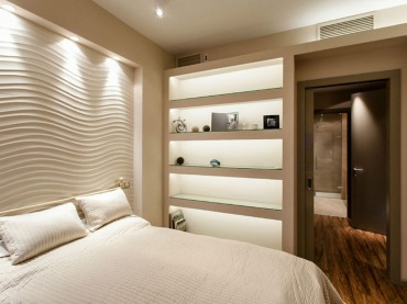 Aranżacja sypialni w stylu nowoczesnym z charakterystycznym oświetleniem. Jasna kolorystyka zapewnia odpowiednie...