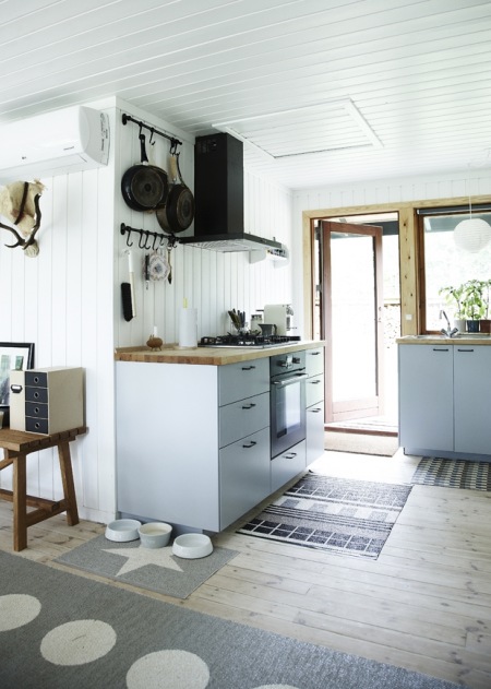 Czarny okap i drewniane blaty w kuchni w stylu skandynawskim