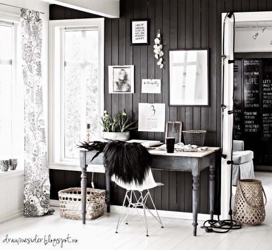 Czarna ściana  z galerią grafik i fotografi w domowym biurze skandynawskim