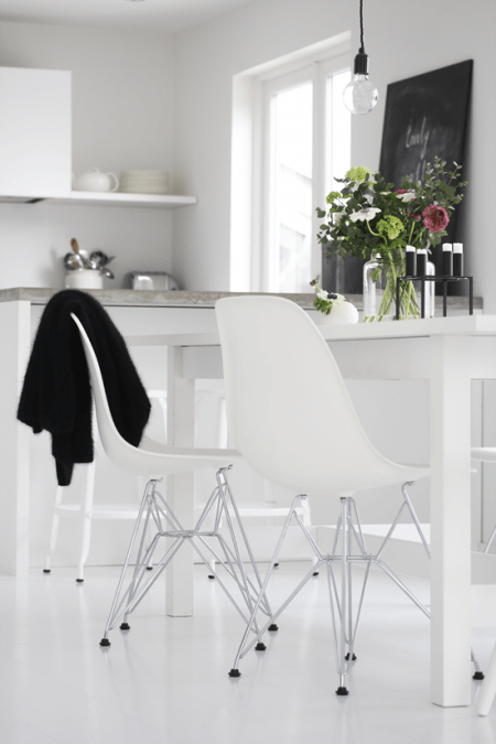 Nowoczesne biale krzesła na metalowych krzyżakach w białej kuchni