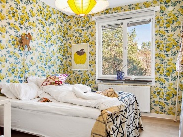 Aranżacja sypialni,sypialnia z kwiatową tapetą na ścianie,żółta tapeta z różami,kwiatowa żółta tapeta ścienna,żółte róże na tapecie,żółta lampa wisząca,biało-czarna narzuta z graficznym wzorem,żółte dodatki we wnętrzach (37975)