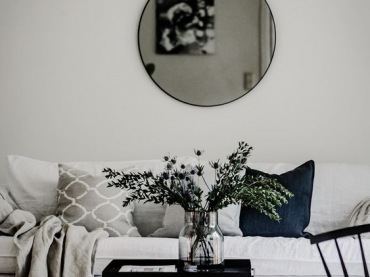 Aranżacja salonu z okrągłym lustrem i białą sofą (54318)