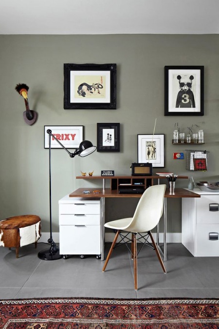 Szare ściany, rustykalny puf,czarna lampa podłogowa i nowoczesne biurko z nadstawką
