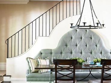 przepięknie zharmonizowana linia schodów i tapicerowanej sofy, lampy wiszącej z wybraną poręczą schodów i krzesłami.