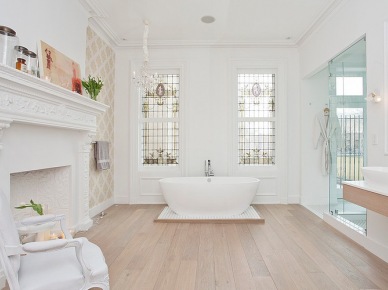 Biały pokój kąpielowy ze stylowym kominkiem,owalną wanną i drewniana podłogą (24435)