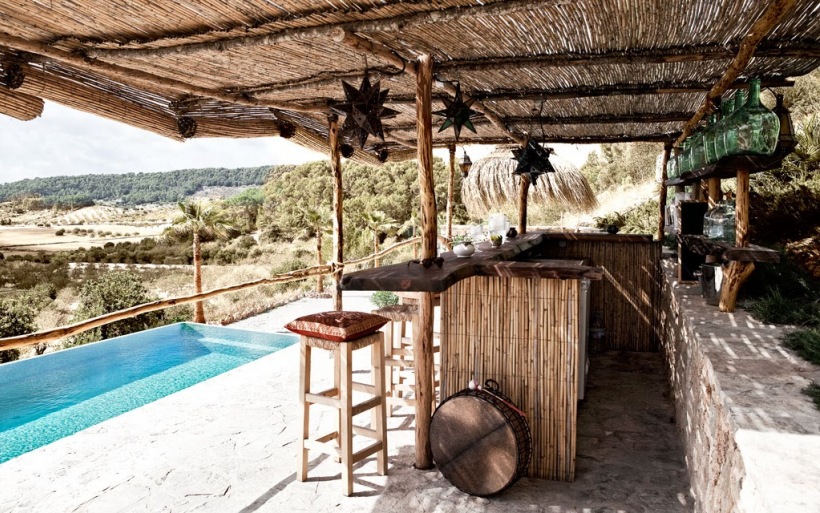 Basen,bambusowy dach nad tarasem,szklane  zielone butle i drewniane stołki z ladą