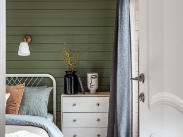 Aranżacja sypialni jest prosta i przy tym oryginalna. Na ścianach znajdują się drewniane deski, które pomalowano na...