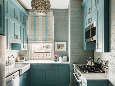 Szafki przemalowane na szaro-błękitny odcień nadają kuchni ciekawy wygląd. Biała podłoga rozświetla wnętrze, a spora...