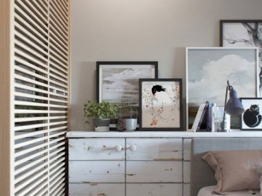Komódka ze starego bielonego drewna podkreśla romantyczny charakter sypialni. Łóżko i dekoracje za nim są raczej...