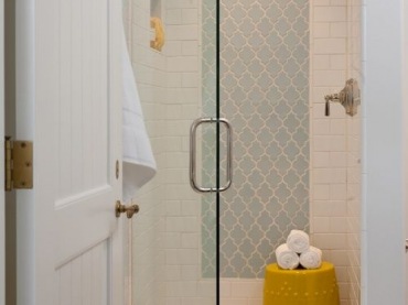 Mała skromna łazienka, w której stonowaną białą aranżację urozmaicono żółtymi dodatkami oraz lekkim wzorem tworzącym...