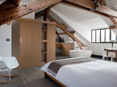 Owalna wanna w biało-brązowej sypialni z drewnianymi belkami i nowoczesnymi krzesłami (24980)