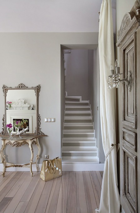 Prowansalska bielona konsolka z lustrem w aranzacji przedpokoju ze schodami