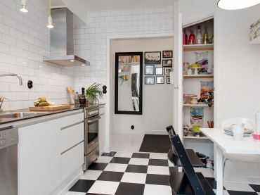 Biało-czarna posadzka w szachownicę,biała płytka cegiełka na ścianie i biało-czarne meble w skandynawskiej kuchni (25882)