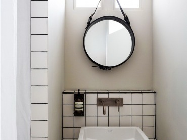 Biała glazura z czarnymi spoinami we wnęce łazienkowej z okragłym lustrem (21164)
