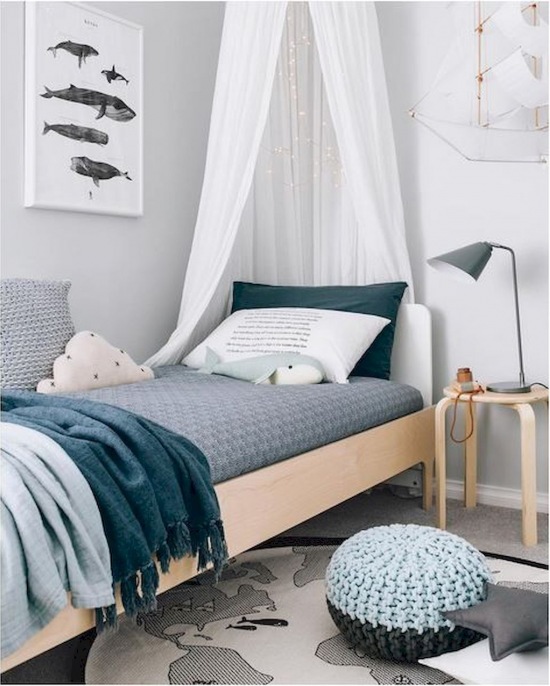 Mała sypialnia z drewnianym łóżkiem i niebieskimi dodatkami