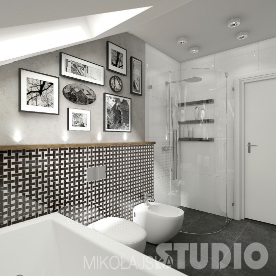 Półokragła szklana kabina z natryskiem w małej łazience z biało-czarną płytka na ścianie wykończoną drewnianą listwą