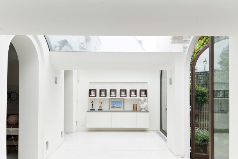 Biała komoda zawieszona na ścianie w nowoczesnej aranżacji pod szklanym dachem