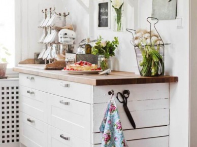 Skandynawska kuchenna komoda z drewnianym blatem,białe półki wiszące na ścianie, szklane i ceramiczne akcesoria w aranżacji kuchni (28238)