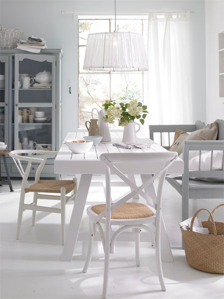 Białe krzesła z drewna gietego i drewniana ławka w stylu skandynawskim przy stole w jadalni