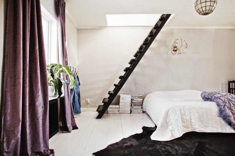 Czarne schody, wrzosowe aksamitne zasłony,biała podłoga i czarna bydlęca skóra w aranżacji sypialni