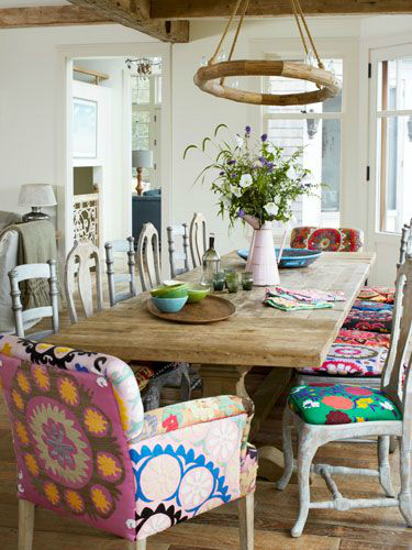 Kolorowe tapicerki na krzesłach i fotelach przy  rustykalnym francuskim stole