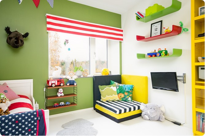 Zielone ściany,czerwono-biała roleta i żółte meble w pokoju dla chłopca