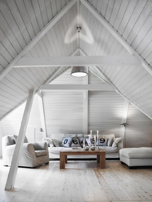 Biały salon pod skośnymi ścianami z białej boazerii,drewniana ława rustykalna i białe sofy z fotelami