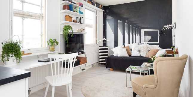 Czarno-biała fototapeta z arkadami w architekticznej perspektywie,czarna sofa,beżowy fotel,pólki na ścianach z TV i białe biurko
