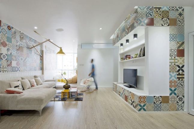 Salon z marokańskimi kolorowymi płytkami na ścianie,naroznikiem,żółtym kinkietem i białymi półkami
