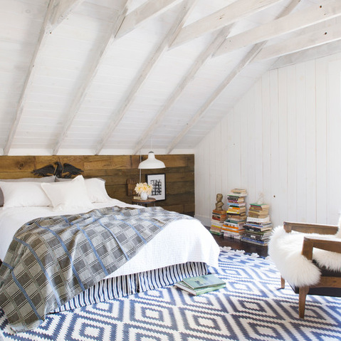 Rustykalna biała sypialnia pod skośnymi ścianami i wezgłowiem z desek