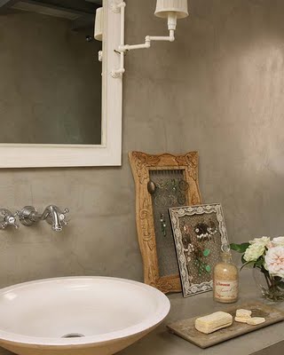 Stylowe ramki vintage w łazience z betonowymi ścianami