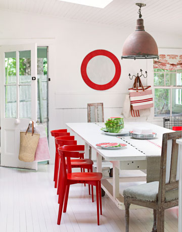 Czerwone krzesła i lustro okragłe w białej jadalni w modern rustykalnyjm stylu