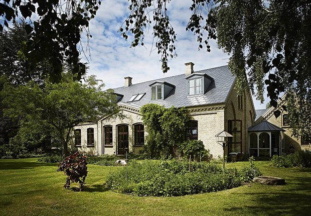 Stylowy dom z historią w jasnej elewacji z cegły i ze starym klasycznym ogrodem