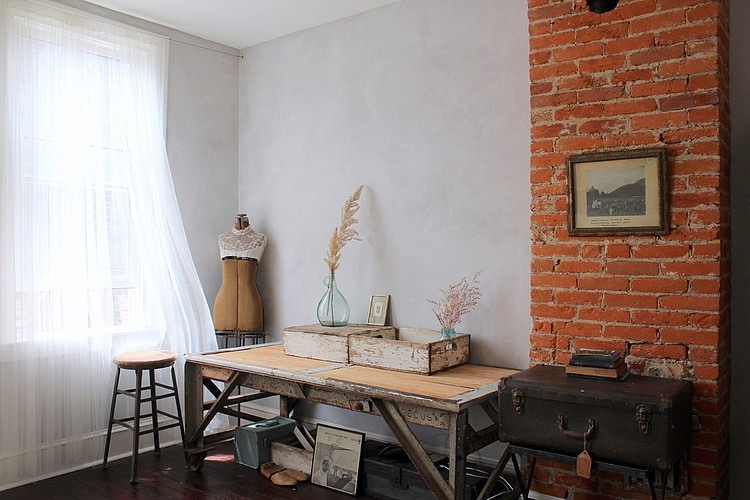 Kącik do pracy z biurkiem vintage i ścianą z cegły