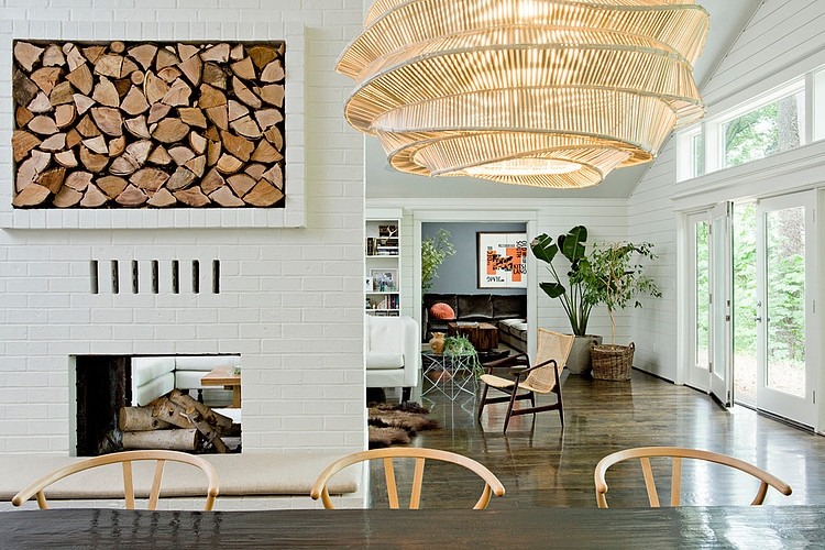 Otwarty salon z kominkiem w ścianie z białej cegły