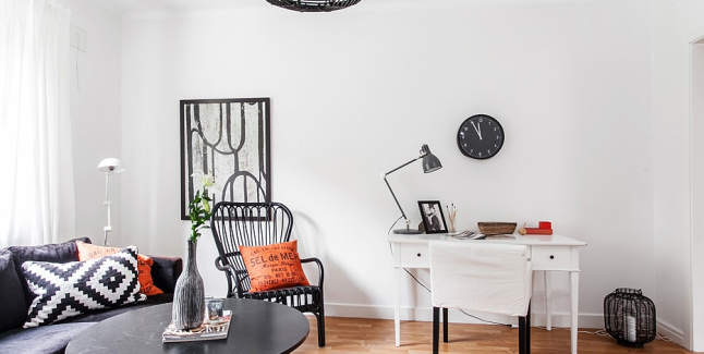 Czarny bambusowy fotel,czarna grafika,czarna sofa i biale biurkow salonie w stylu skandynawskim